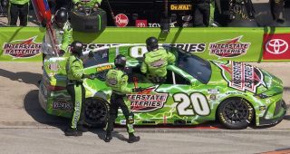 No. 20 crew member goes into car to fix Bell’s helmet hose