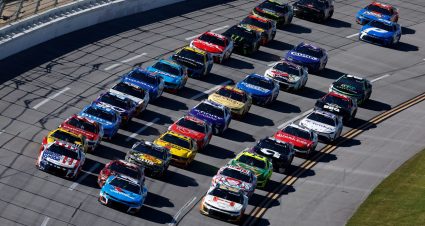 NASCAR Cup Series cars race to the start-finish line on May 11, 2025 at Kansas Speedway.