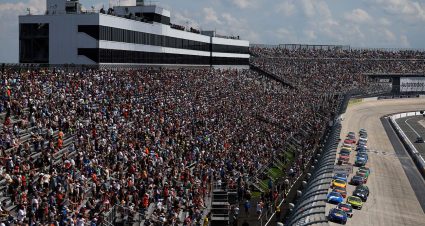 NASCAR Cup Series cars race to the start-finish line on May 11, 2025 at Kansas Speedway.