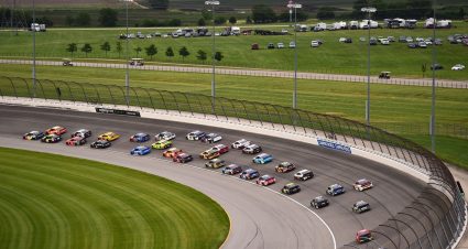 NASCAR Cup Series cars race to the start-finish line on May 11, 2025 at Kansas Speedway.