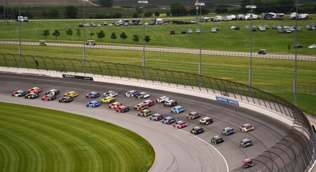 NASCAR Cup Series cars race to the start-finish line on May 11, 2025 at Kansas Speedway.