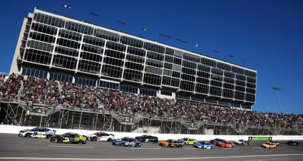 NASCAR Cup Series cars race to the start-finish line on May 11, 2025 at Kansas Speedway.