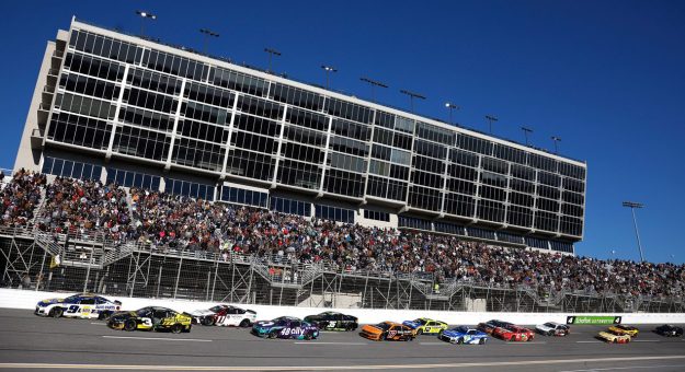 NASCAR Cup Series cars race to the start-finish line on May 11, 2025 at Kansas Speedway.